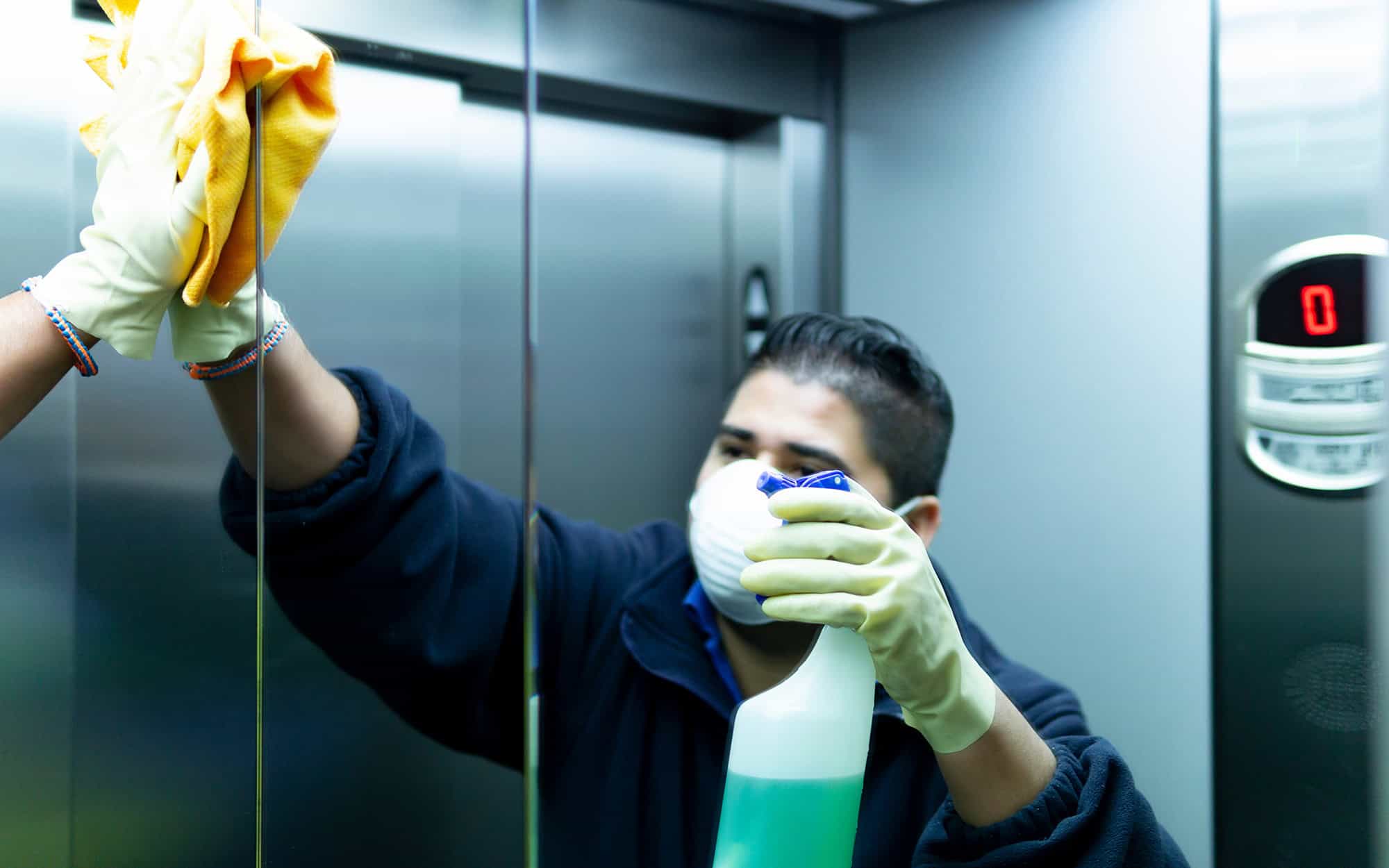 Mirror View Of A Man Cleaning Elevator